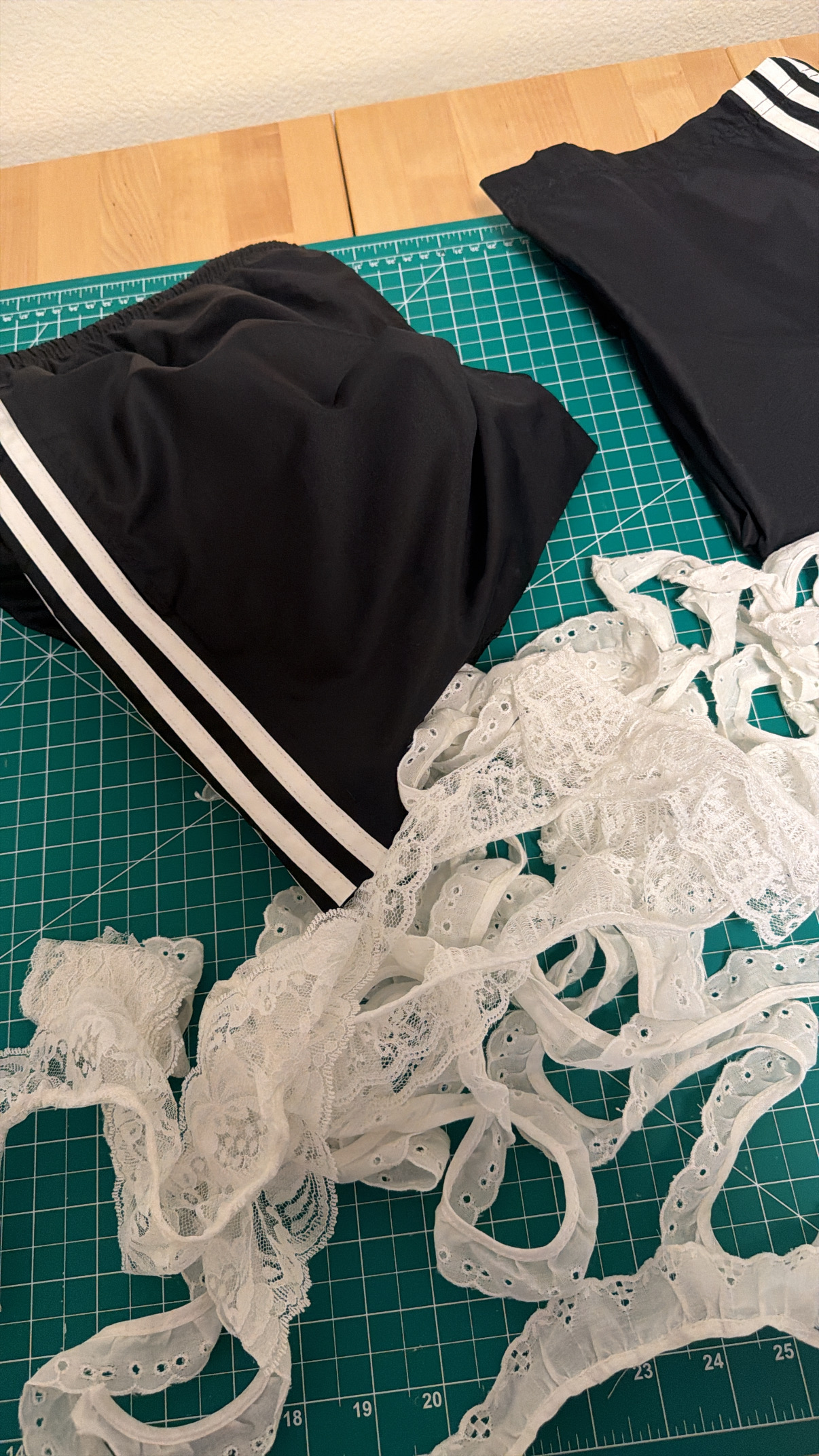 All the lace trim options laid out next to the thrifted Adidas sweatpants